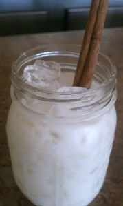 Mason jar ful of homemade horchata with a cinnamon stick